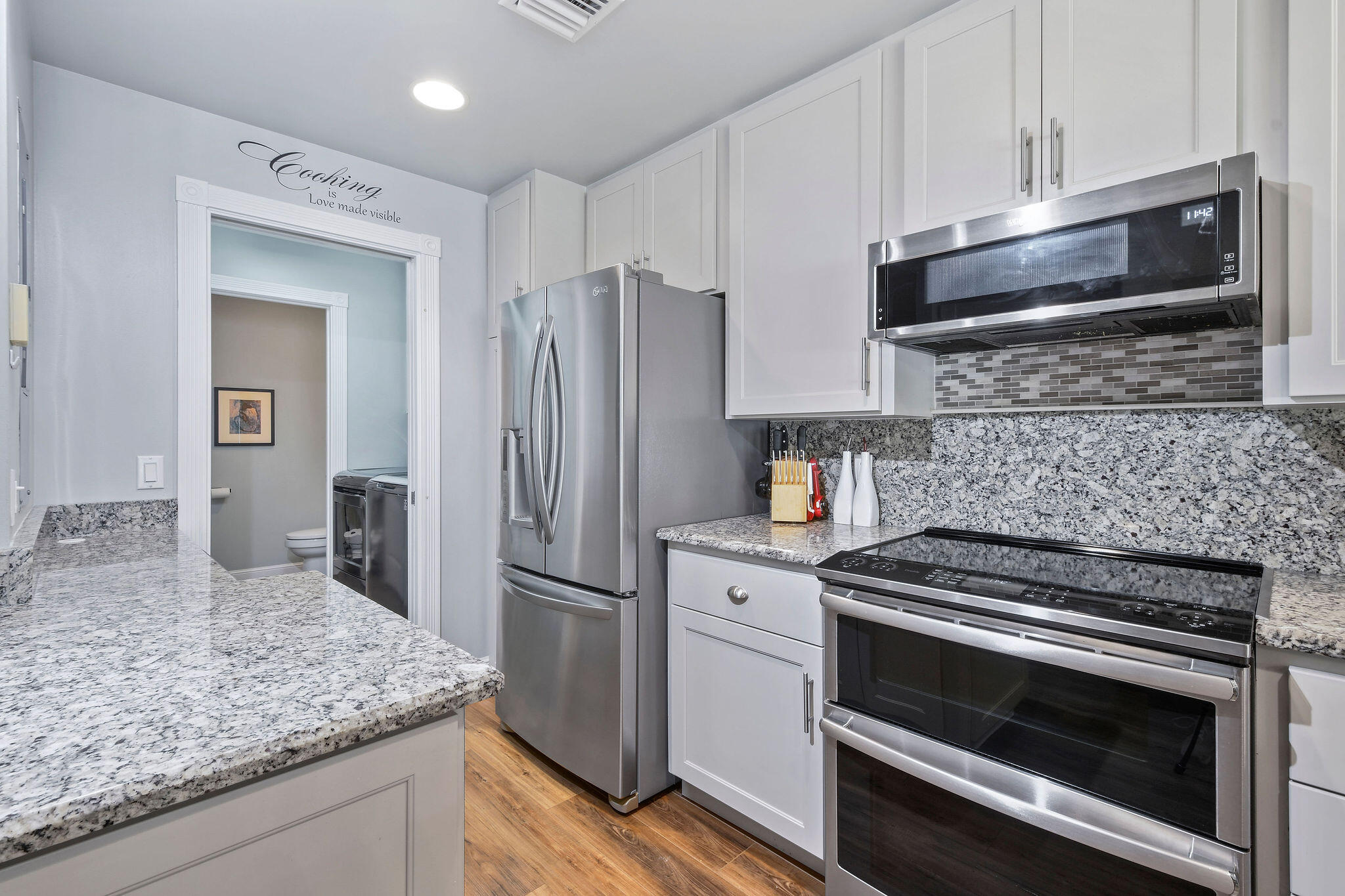 111 Ashley Court Jupiter, FL 33458 - Photo 14 of 68 a kitchen with granite countertop wooden cabinets and stainless steel appliances