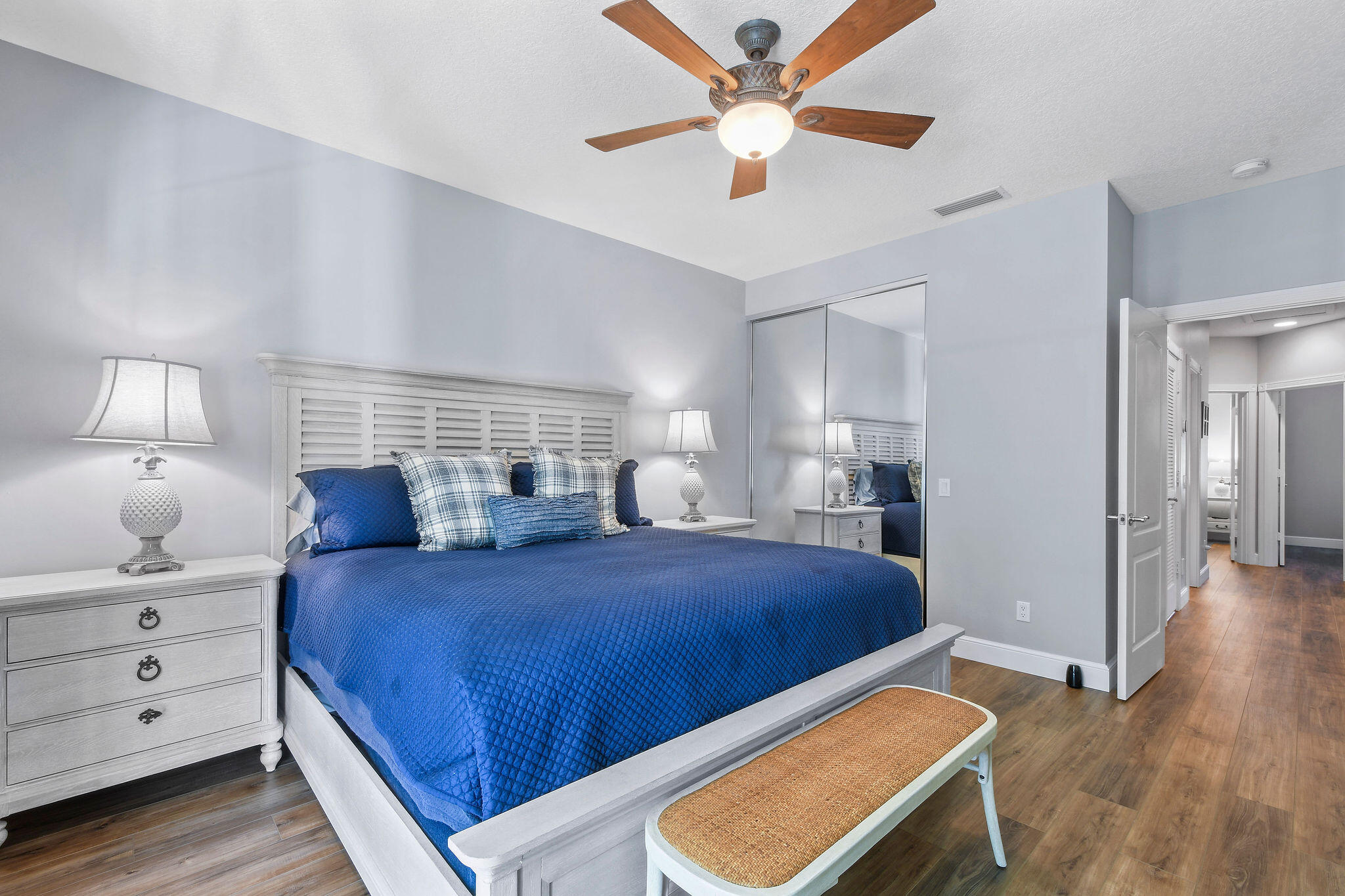 111 Ashley Court Jupiter, FL 33458 - Photo 28 of 68 a bedroom with a large bed and a chandelier