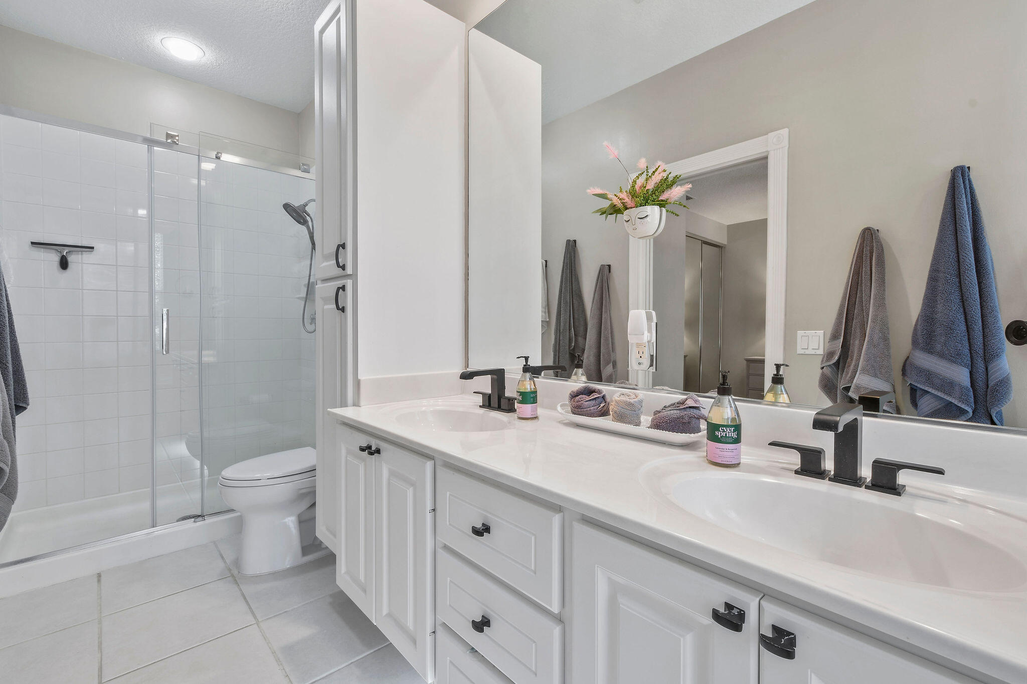 111 Ashley Court Jupiter, FL 33458 - Photo 30 of 68 a bathroom with a double vanity sink and a mirror