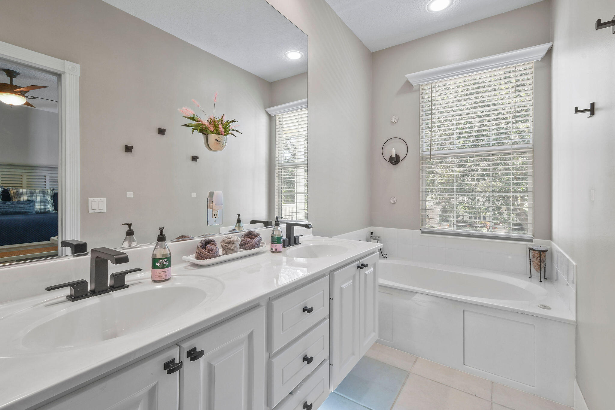 111 Ashley Court Jupiter, FL 33458 - Photo 31 of 68 a bathroom with a tub a sink double vanity and a mirror