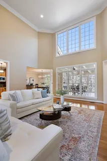 a view of a dining room and livingroom with furniture wooden floor a chandelier