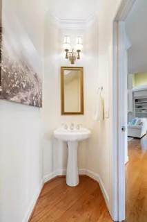 a dining room with wooden floor a chandelier a glass table and chairs
