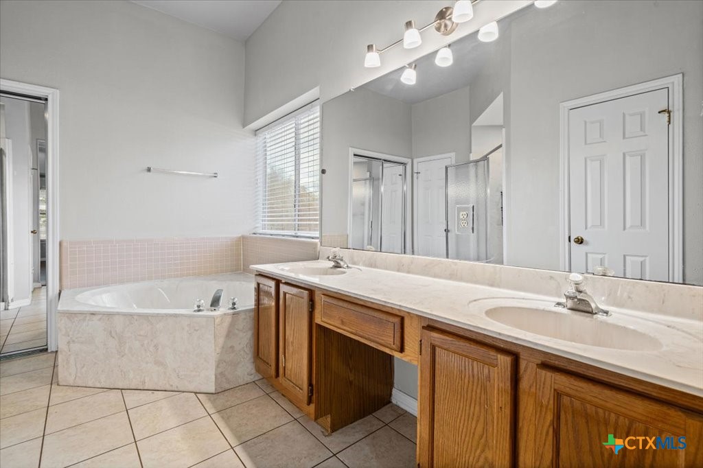 12502 Fallen Tower Lane Austin, TX 78753 - Photo 14 of 28 a bathroom with a tub a sink and mirror
