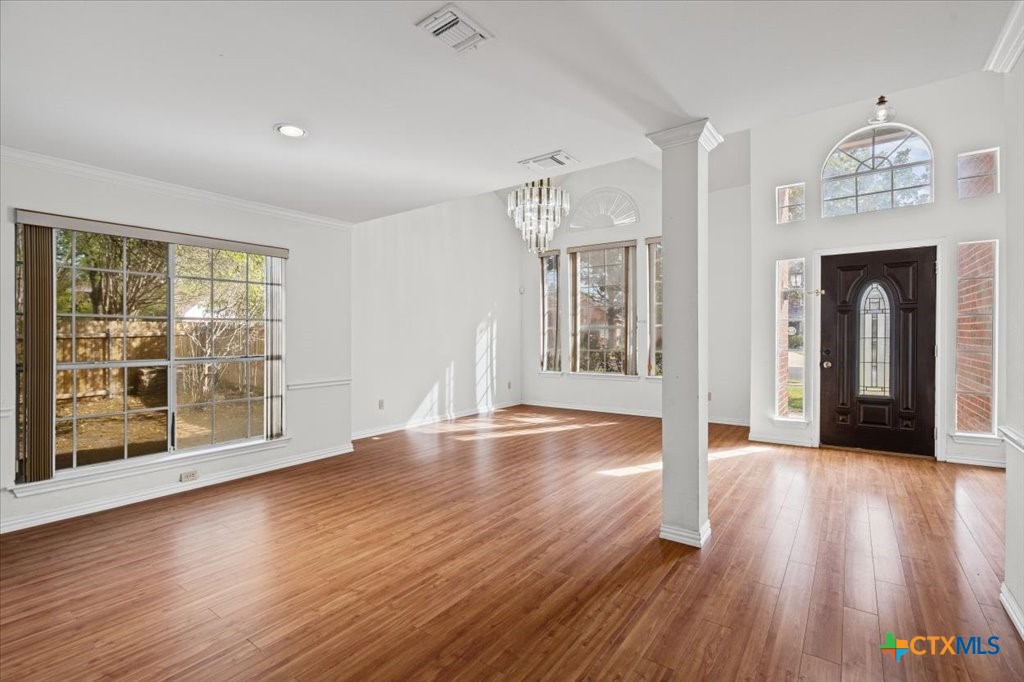 12502 Fallen Tower Lane Austin, TX 78753 - Photo 4 of 28 an empty room with wooden floor fireplace and windows
