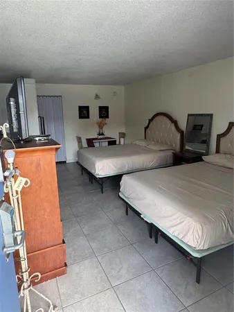 a large bedroom with bed and mirror