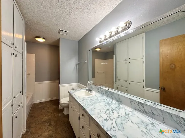 a bathroom with a granite countertop double vanity sink and mirror