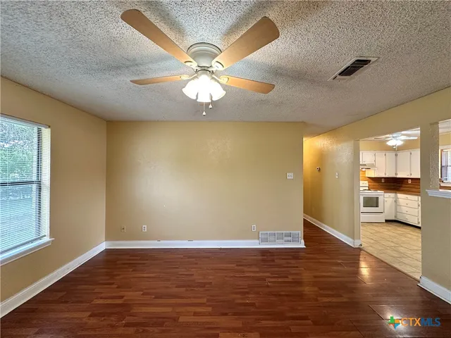 a view of a livingroom with a ceiling fan and wooden floor