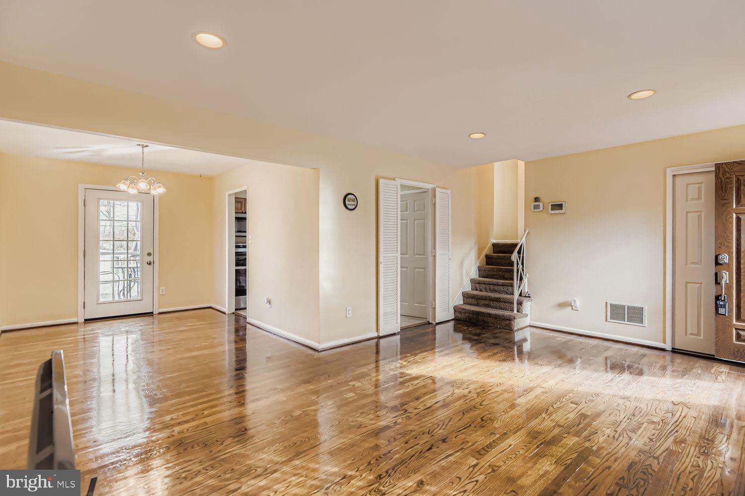 8504 Fieldway Drive Randallstown, MD 21133 - Photo 16 of 20 a view of an empty room with wooden floor and stairs