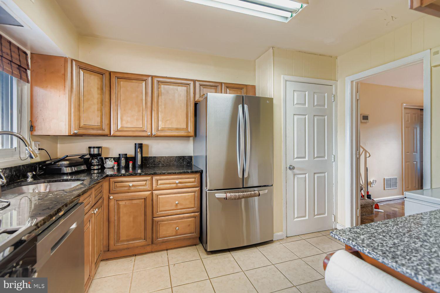 8504 Fieldway Drive Randallstown, MD 21133 - Photo 4 of 20 a kitchen with a refrigerator sink and cabinets