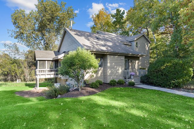 a view of a house with a yard and a large tree
