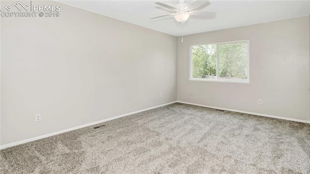 2040 South Chelton Road Colorado Springs, CO 80916 - Photo 12 of 27 Enormous Master Bedroom with new carpet, interior paint and ceiling fan and walk in closet.