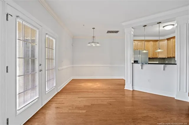 an empty room with fireplace cabinet and windows