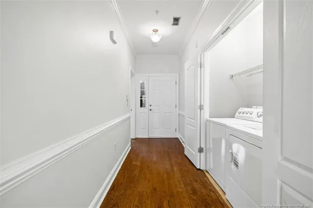 an empty room with a chandelier fan and windows