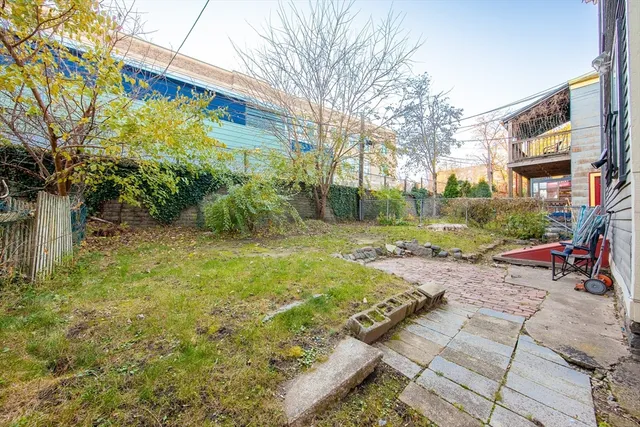 a view of a yard with plants and a bench