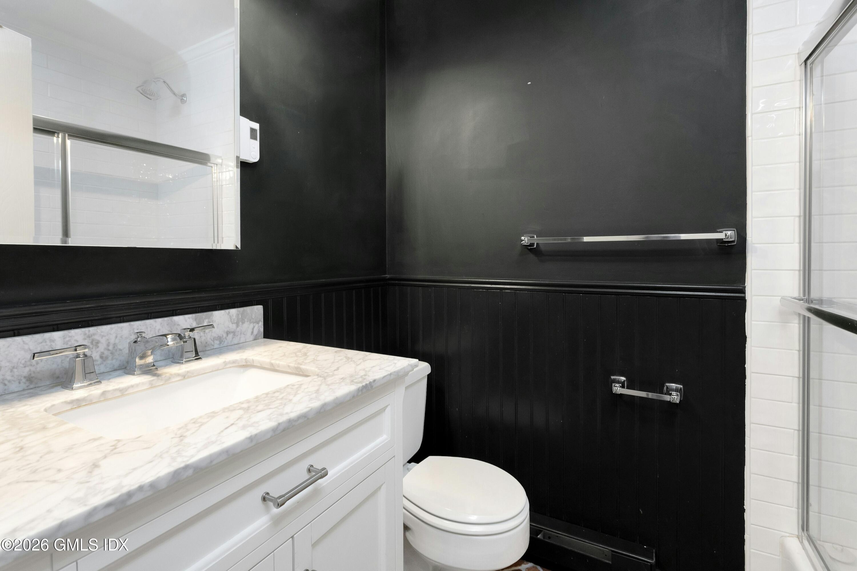 9 Weaver Street, Unit 9 Greenwich, CT 06831 - Photo 11 of 18 a bathroom with a granite countertop sink toilet and mirror