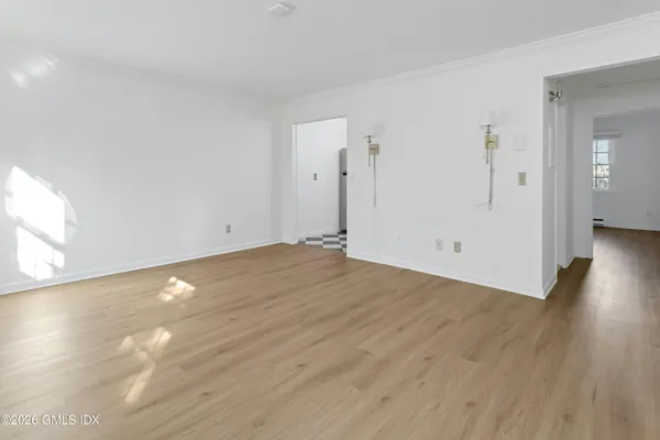 a view of empty room with wooden floor