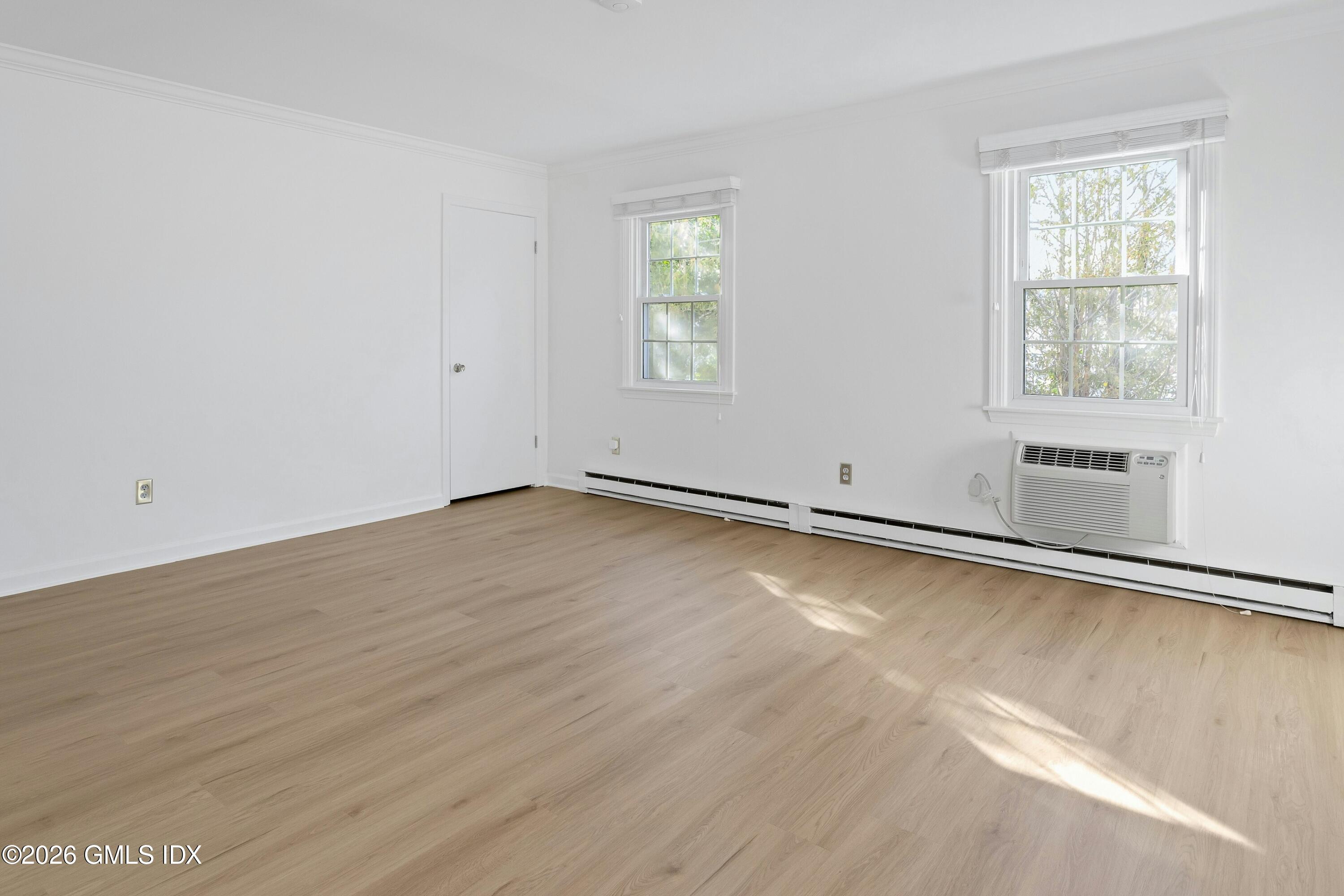9 Weaver Street, Unit 9 Greenwich, CT 06831 - Photo 6 of 18 an empty room with wooden floor and windows