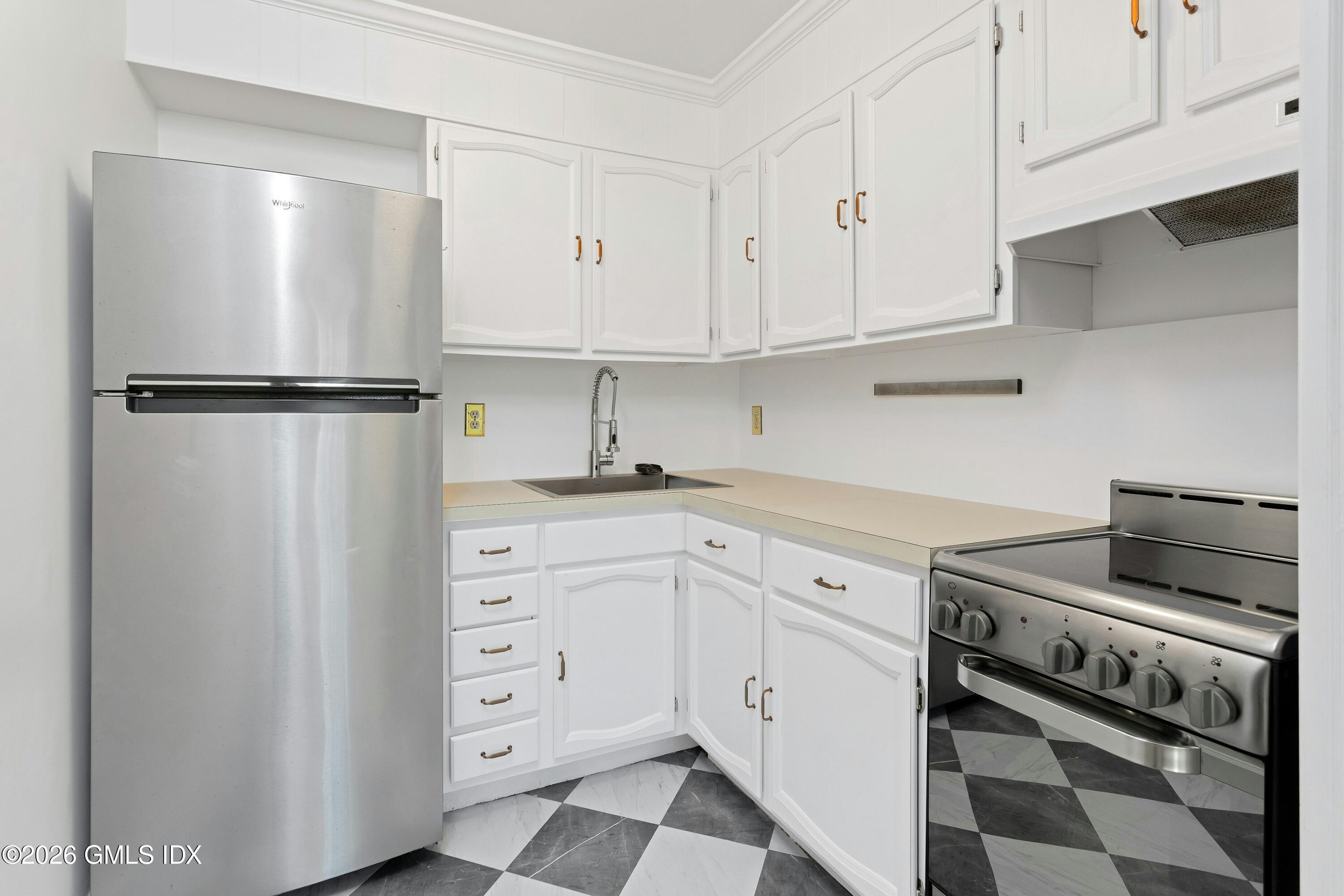 9 Weaver Street, Unit 9 Greenwich, CT 06831 - Photo 7 of 18 a kitchen with white cabinets and white appliances