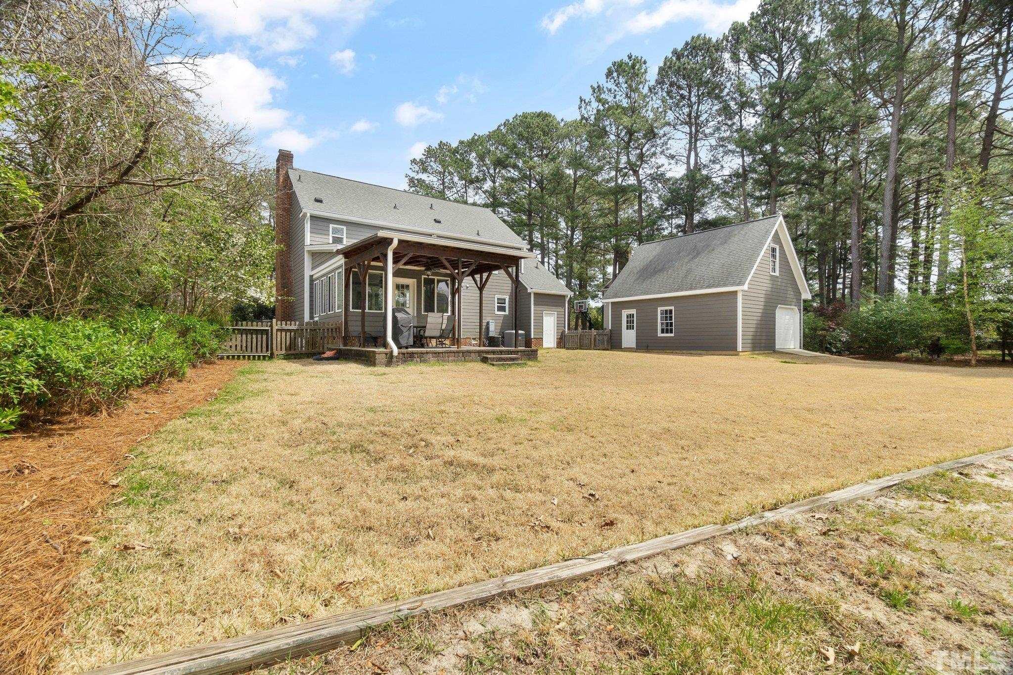 2761 Farnborough Road Raleigh, NC 27613 - Photo 26 of 30 a backyard of a house with large trees and barbeque oven