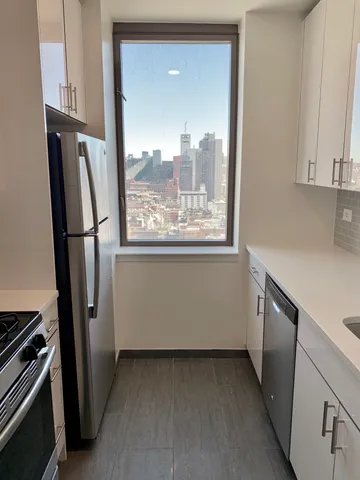 a view of a kitchen with fridge and wooden floor