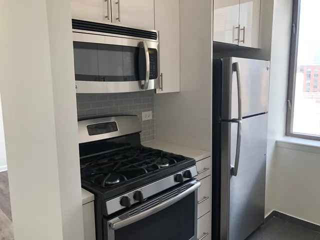 a kitchen with stainless steel appliances a stove a microwave and a refrigerator