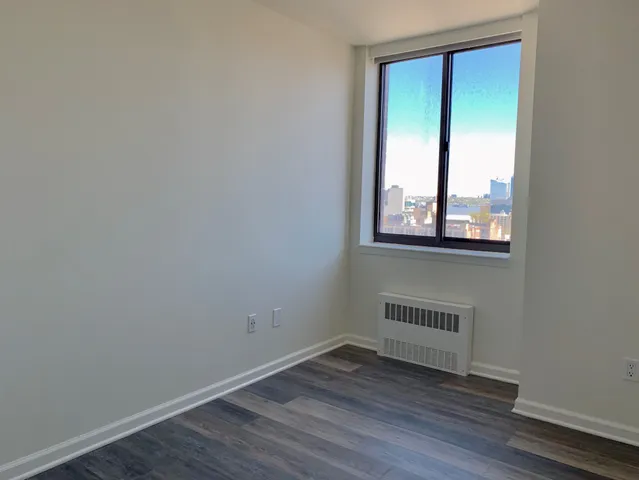 a view of a small space with wooden floor and a window