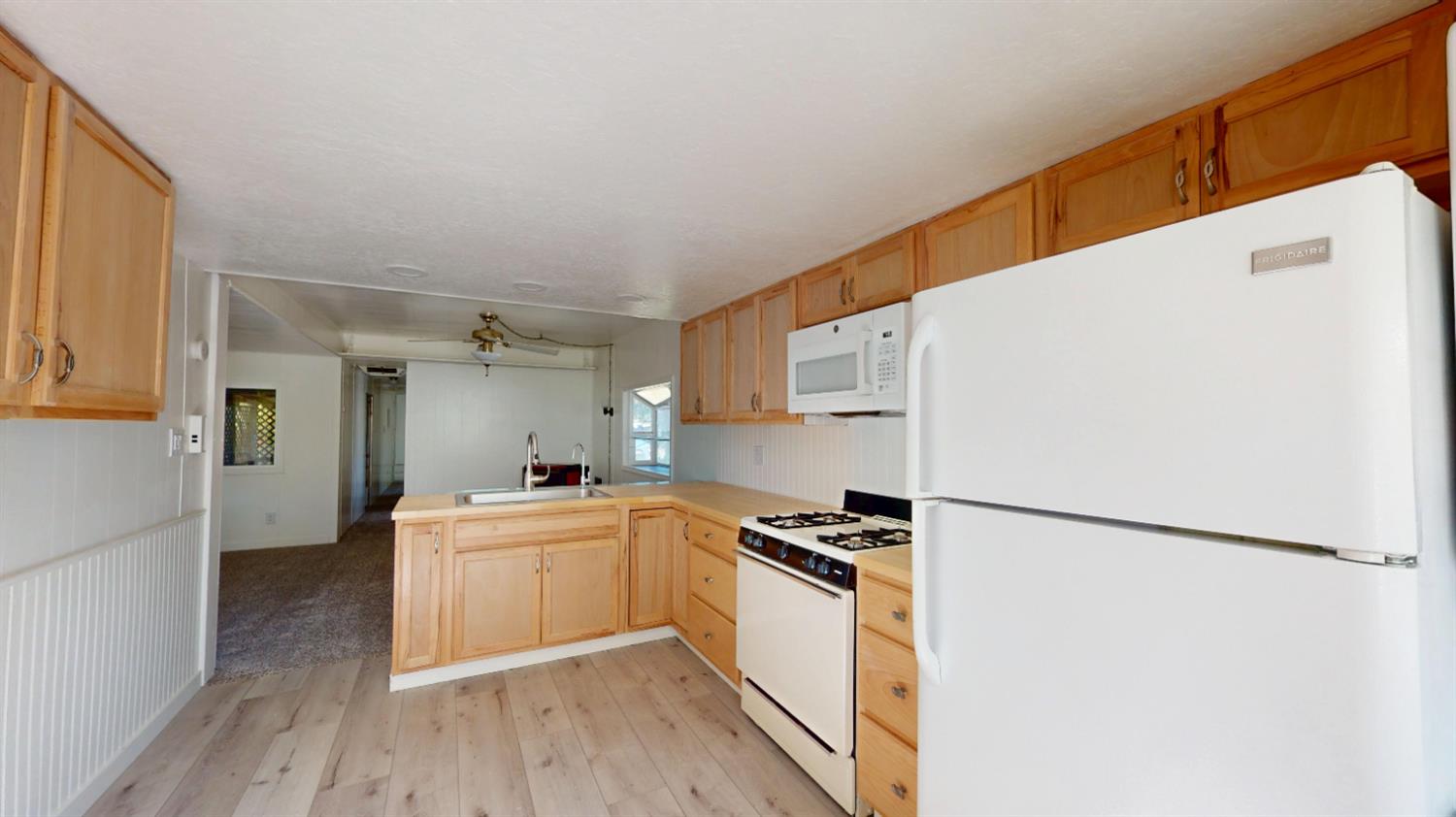 a kitchen with a refrigerator a stove top oven and a wooden floor
