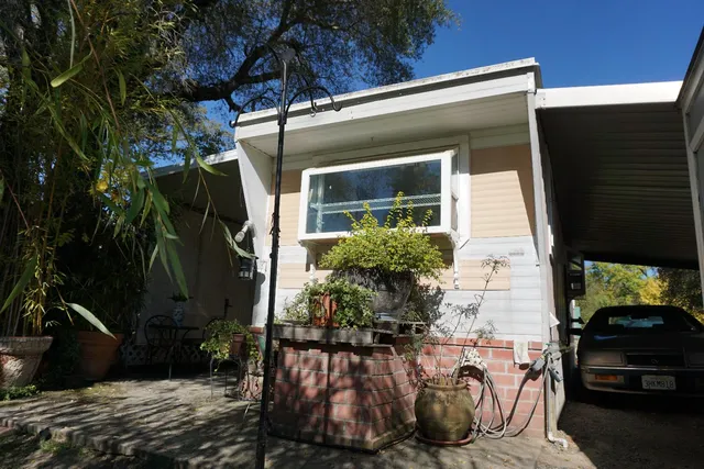 a view of a house with backyard and sitting area