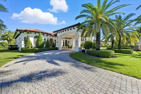 a front view of a house with a yard and potted plants
