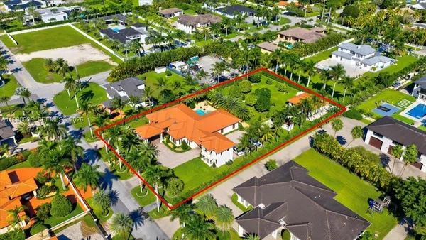 an aerial view of a house with swimming pool and garden