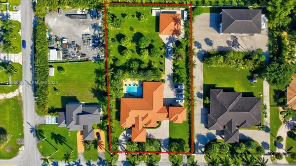 an aerial view of residential houses with outdoor space and trees all around