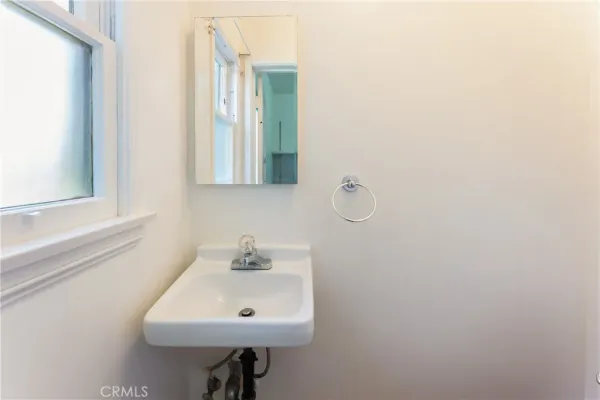 a bathroom with a sink a mirror and a window