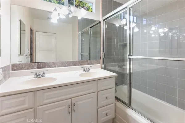 a bathroom with a sink shower and a mirror