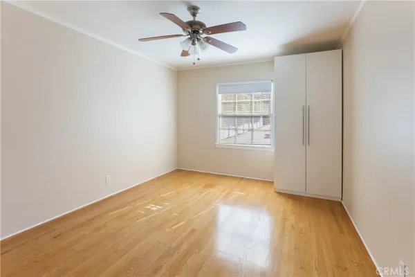 an empty room with windows and fan