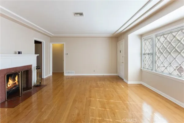 a view of an empty room with window and fire place