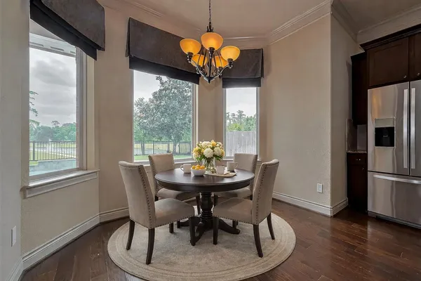 a dining room with furniture a chandelier and wooden floor