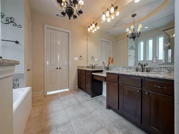 a spacious bathroom with a granite countertop sink a large mirror and a shower