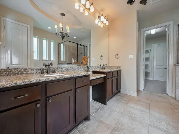 a bathroom with a granite countertop sink a large mirror and a shower