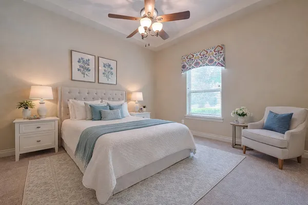 a spacious bedroom with a bed and a chandelier