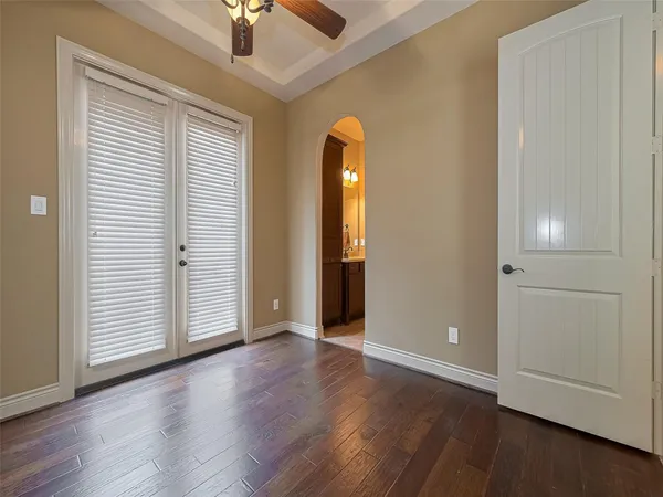 an empty room with wooden floor cabinet and windows