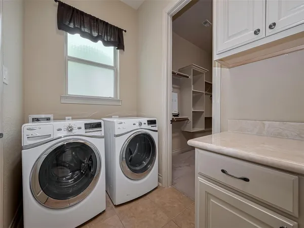 a kitchen with white cabinets and sink