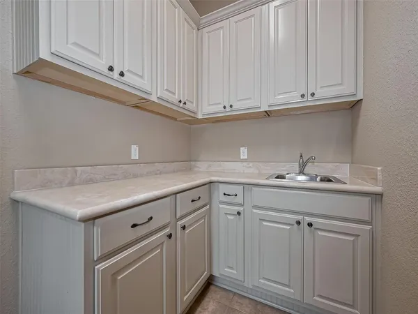 a utility room with stainless steel appliances granite countertop a sink a washer and dryer