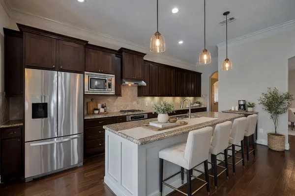 a kitchen with stainless steel appliances a stove a sink a microwave a refrigerator and chairs