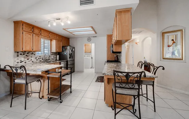 a large kitchen with stainless steel appliances granite countertop a stove and a sink