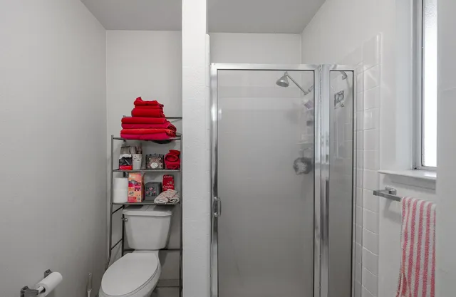 a view of an empty room with chandelier fan and wooden floor