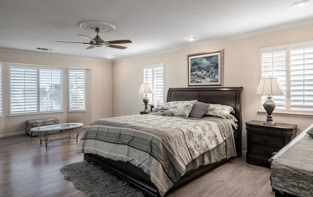 a spacious bedroom with a bed a mirror and a flat screen tv