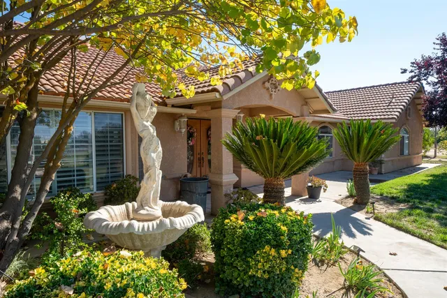 a view of a house with a yard and potted plants