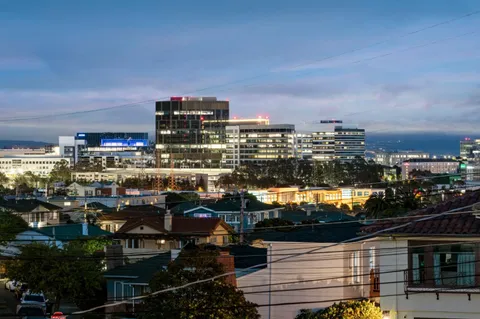 a view of an empty room with window and hardwood floor