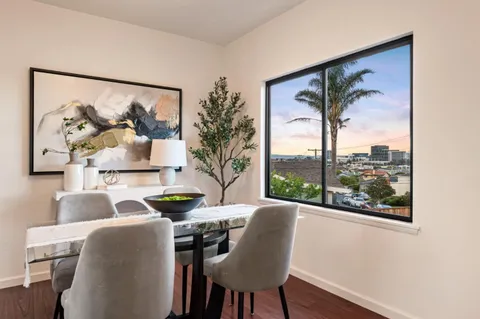 a view of a dining room with furniture a chandelier and wooden floor