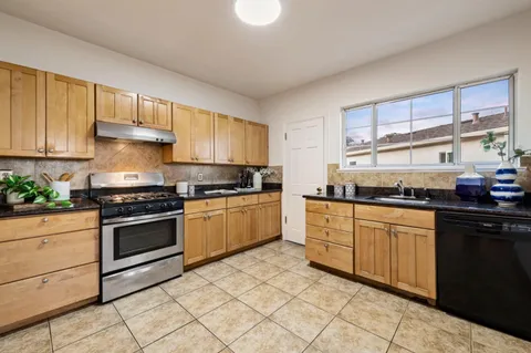 a kitchen with granite countertop cabinets stainless steel appliances and a window